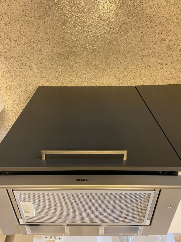 Pent kjøkken med mørke fronter og stålhåndtak 2